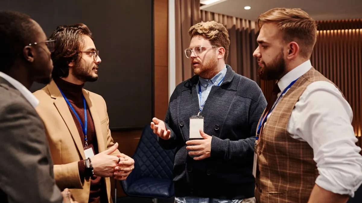 Skupina mužů diskutuje s jmenovkami na konferenci