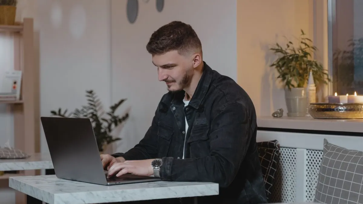 Muž pracuje s notebookem u stolku doma večer